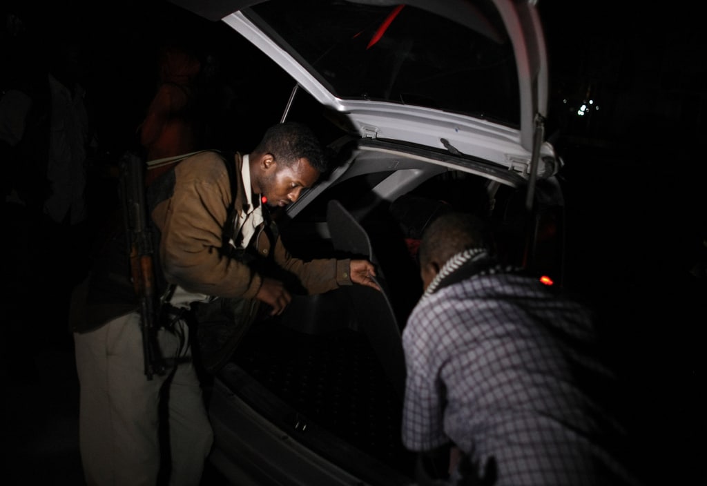 Nigerian Policeman searching a vehicle