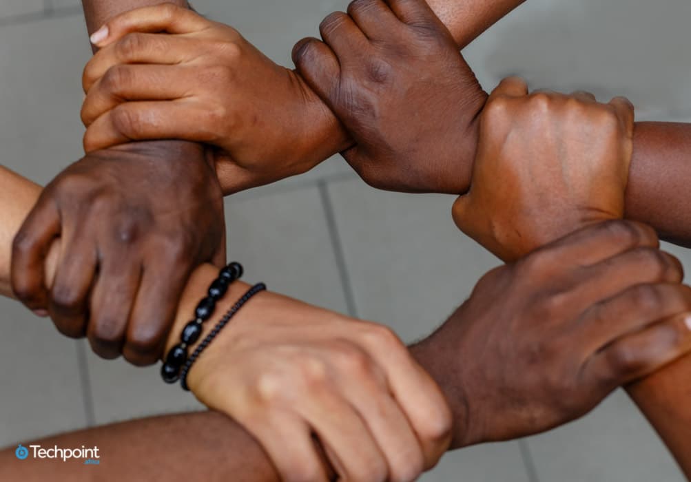 An image of people holding hands depicting support, collaboration, and teamwork