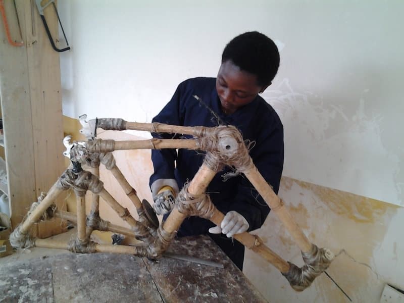 Winnifred Selby putting finishing touches on a bamboo bike frame