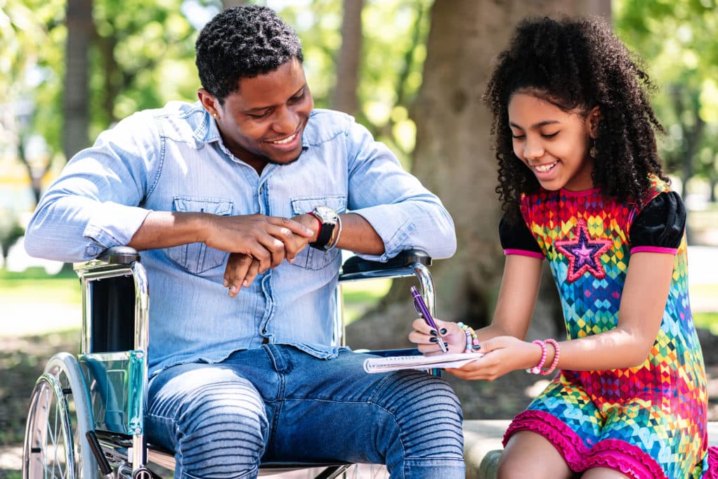 african american man wheelchair enjoying having fun with her daughter park 1