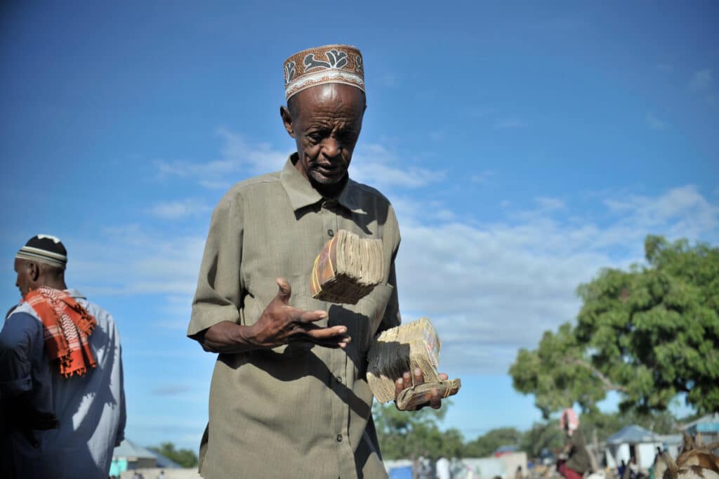 A Somali man carries the money he earned from selling goats at Bakara Animal Market in Mogadishu, Somalia, on April 13. Once notorious for being both the site of Black Hawk Down, in which 18 American soldiers were killed in 1993, and later as an al-Shabaab stronghold, Bakara market is now slowly losing its past notoriety and becoming better known for its thriving economy. In the district's animal market, thousands of goats are now brought each morning, where they are sold on to later be slaughtered for their meat. AU UN IST PHOTO / TOBIN JONES.