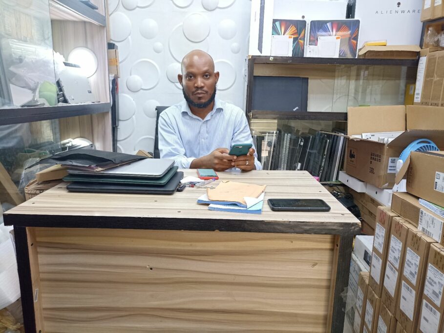 Clement Akwe sitting behind a desk at his shop