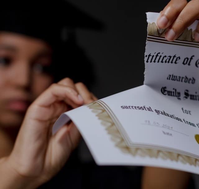 A black female student tearing up certificate of graduation