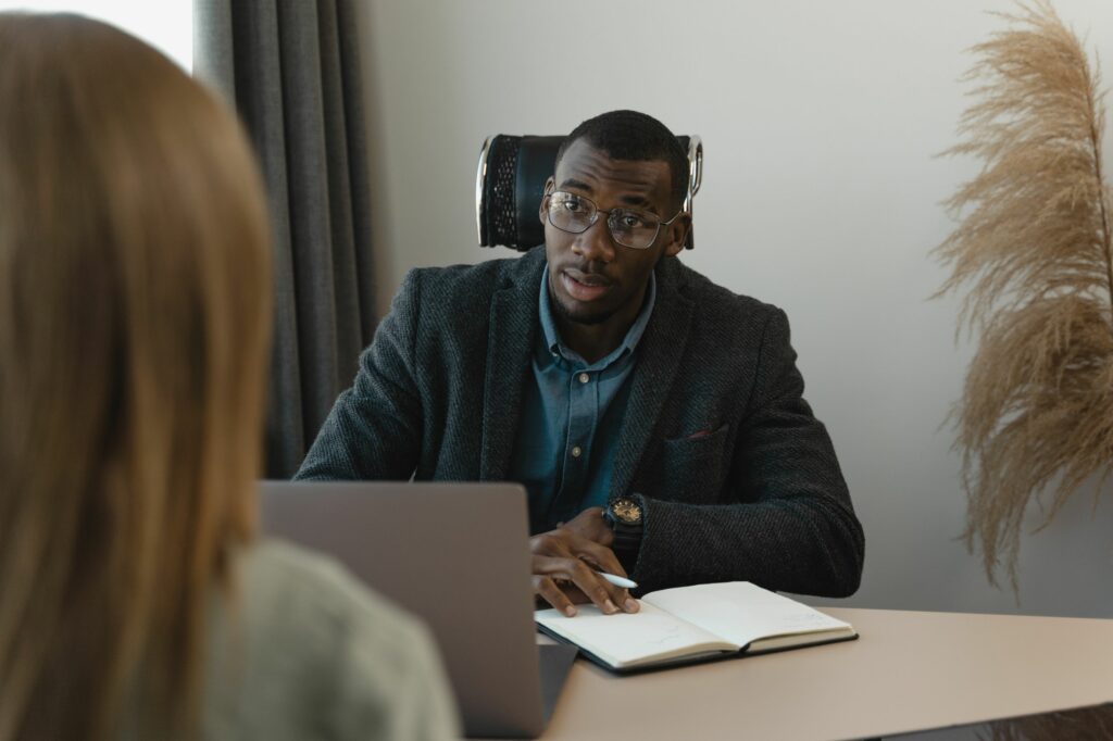 An image showing a male recruiter speaking to a female candidate