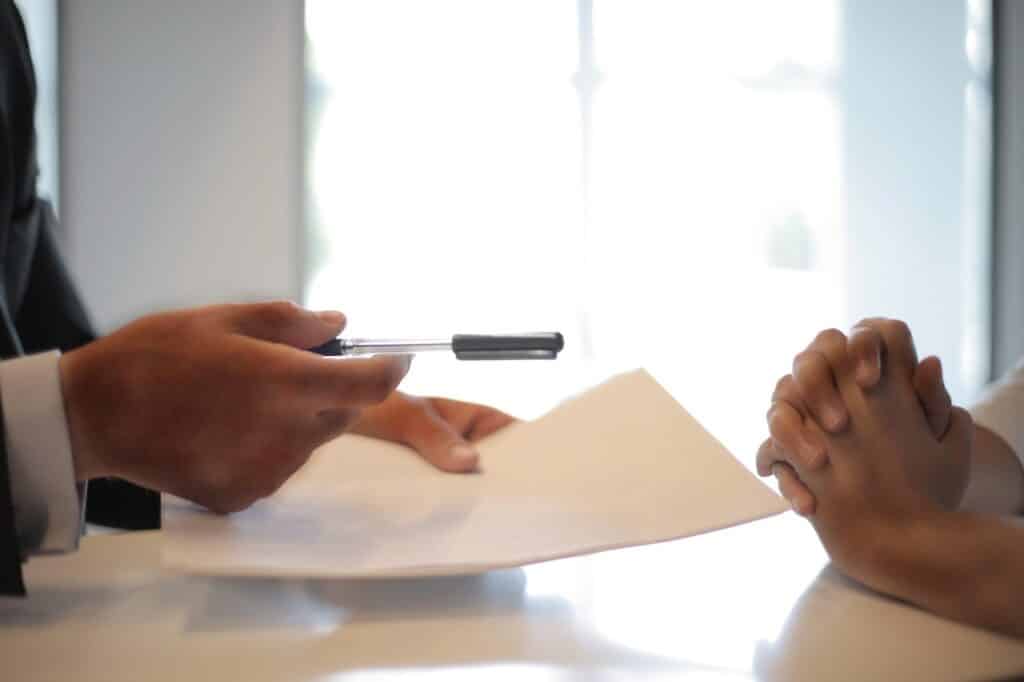 Businessman giving contract to woman to sign