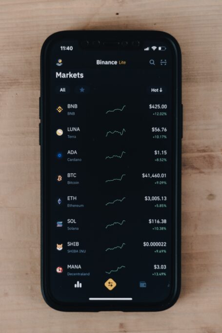 A phone with crypto market charts on the screen