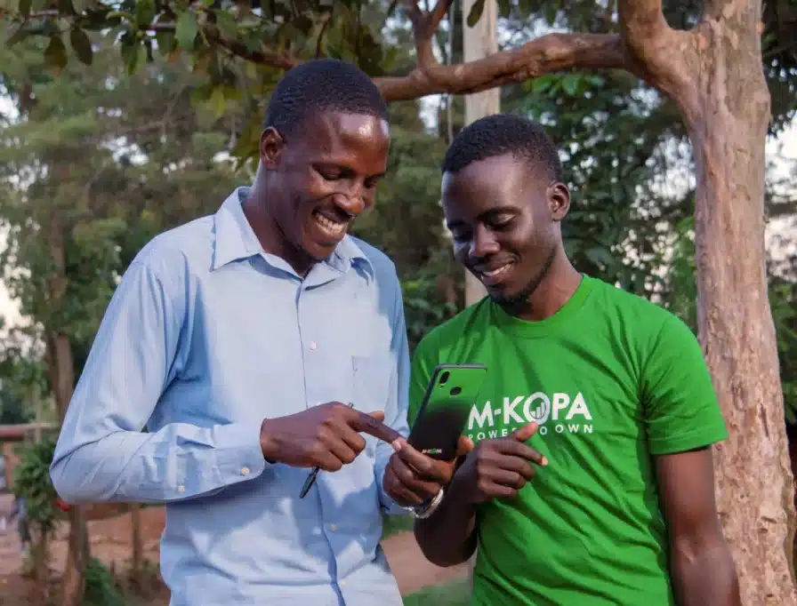 M-KOPA agent and customer looking at a smartphone