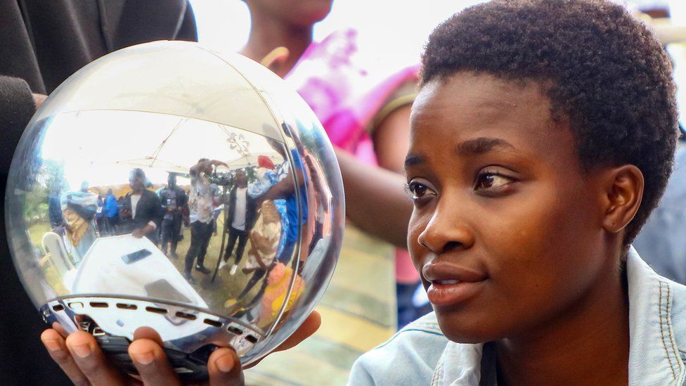 A woman staring into Worldcoin's Orb to scan her iris