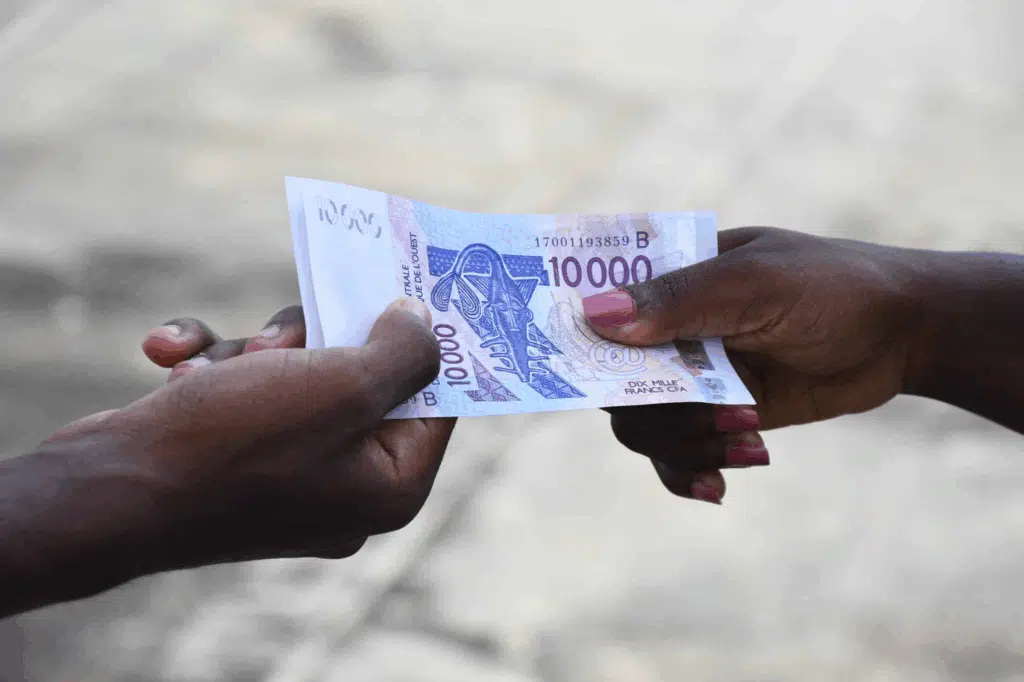 two black hands touching a currency